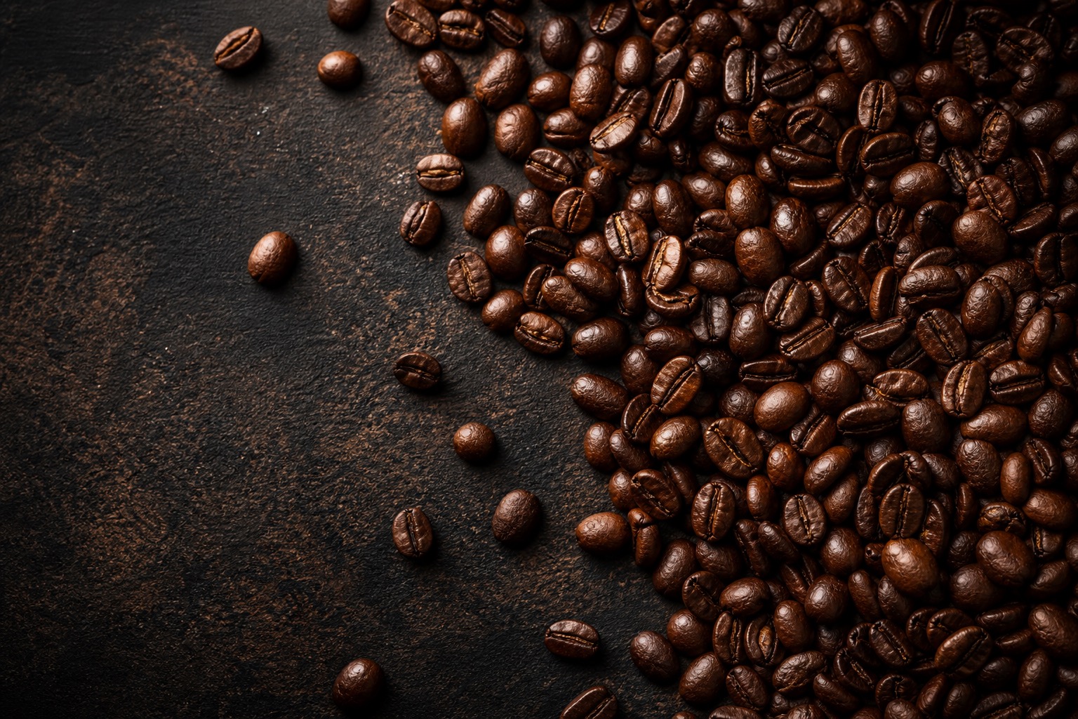 Fresh roasted coffee beans on a dark artisan surface